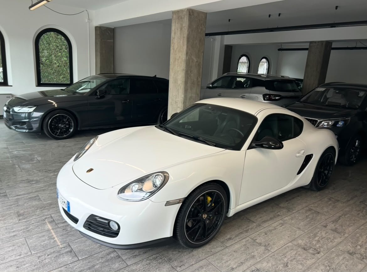 Lo showroom interno di Madè Auto e Moto, con le auto esposte sotto le finestre ad arco